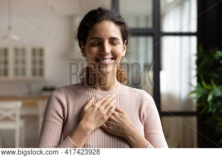 Peaceful Hispanic Female With Closed Eyes Keep Hands To Heart