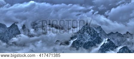 Mountain Peaks Of The Alps Surrounded By Clouds - Fog Stormy Day