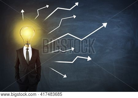 Creative Idea And Business Concept With Man In Black Suit With Light Bilb On Shoulders On Blackboard