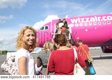 Vilnius, Lietuva, 1.09.2020 - Smiling Blonde Girl Looking At Camera On Airfield. Passengers Boarding