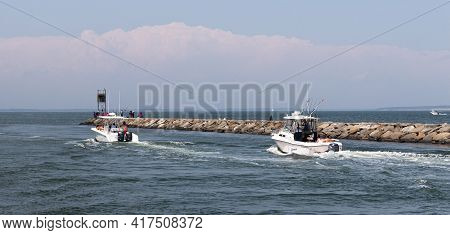 Hampton Bays, New York, Usa - 6 June 2020: Two Moter Boat Next To A Rock Jetty Entering The Great Pe