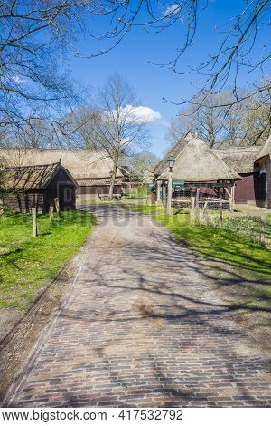 Orvelte, Netherlands - April 16, 2021: Cobblestoned Street And Buildings With Thatched Roofs In Orve