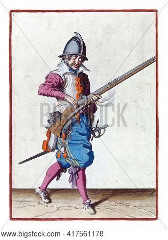 A soldier, full-length, to the right, closing the pan (the powder container) of his helm  with his right hand. In his left hand, in addition to the rudder, also a burning fuse
