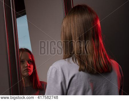 Young Woman Looking At Her Mirror Reflection With Grief. Unhappy Sad Person. Psychological Concept O