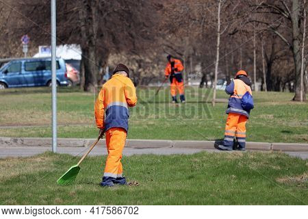 Janitors Clean The Lawns And Streets In Spring City. Street Sweepers With Rake And Broom, Work Of Ho
