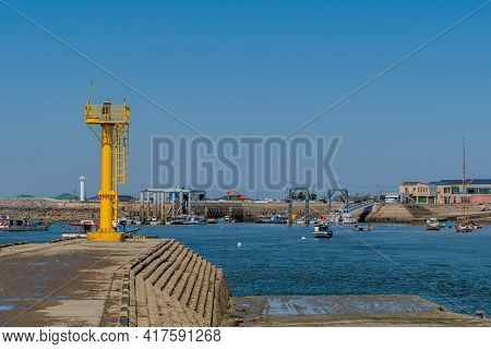 Pyeontaek, South Korea; April 14, 2021: Yellow Lighthouse On Concrete Pier Overlooking Jeongok Port.