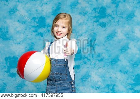 Little Girl Is Playing With A Ball.the Concept Of Childrens Sports, Summer Outdoor Recreation.
