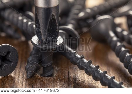 A Screwdriver And Screw On A Wooden Background. Screwdriver Of Chromium Vanadium Steel. Construction