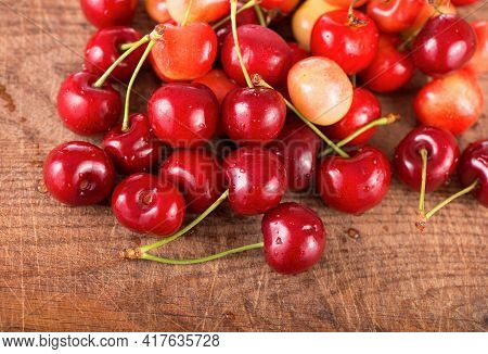Cherries On Wooden Table With Water Drops Macro Background