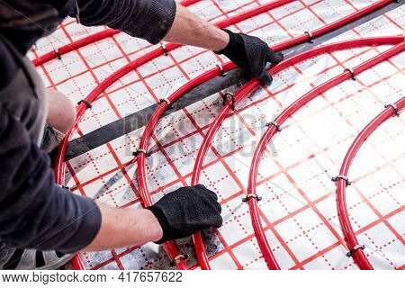 Pipefitter Install System Of Underfloor Heating System At Home