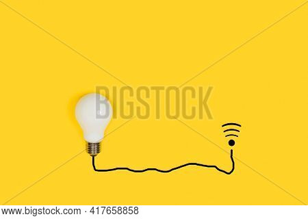 Lightbulb Conected To A Wi Fi Symbol By A Black Line On A Yellow Background
