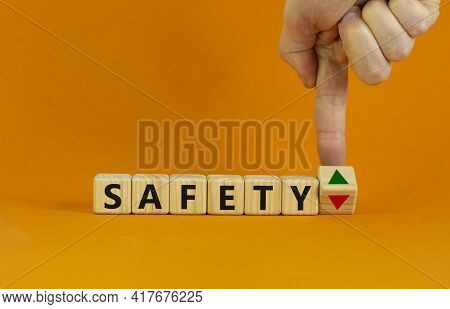 Safety Level Symbol. Businessman Turns A Cube And Changes The Expression 'safety Down' To 'safety Up
