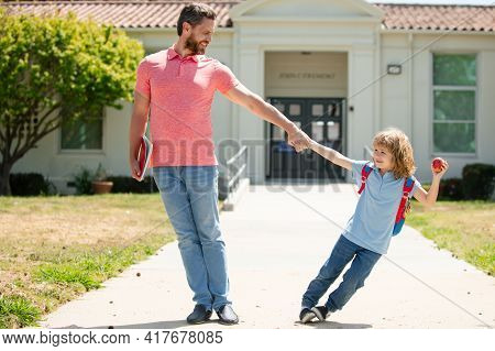 Father And Son Go To School, Education And Learning. Parent And Pupil Of Primary School Schoolboy Wi
