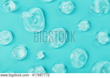 Drops Of Gel With Hyaluronic Acid In The Form Of A Smear Of Glossy Texture On A Cyan Background.