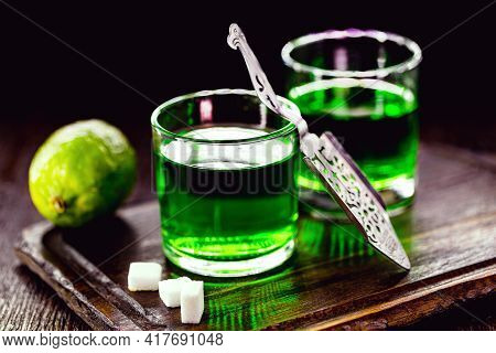 Doses Of Absinthe With Brown Sugar Cubes. Distillate Of Absinthe In A Glass And Lemon, Stainless Ste