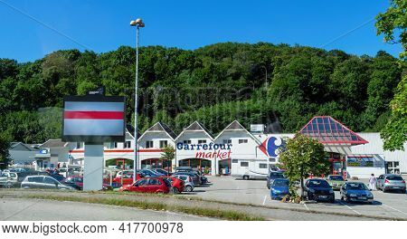 France - Aug 17, 2017: Large Carrefour Supermarket Mall With Forest In Background Parked Cars And Pe