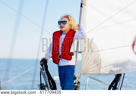 Kids Sail On Yacht In Sea. Child Sailing On Boat. Little Boy In Safe Life Jackets Travel On Ocean Sh