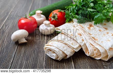 Thin Lavash On Wooden Background With Fresh Vegetables. Armenian Pita Bread - Unleavened Flat Bread.