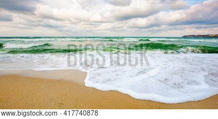 Sea Tide On A Cloudy Sunset. Green Waves Crashing Golden Sandy Beach. Storm Weather Approaching. Sum
