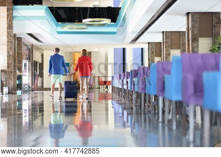 Man And Woman Are Walking With Suitcase Around Hotel