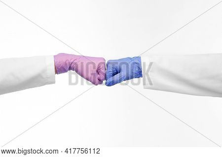 medicine, health protection and healthcare concept - hands of doctors in gloves make fist bump gesture over white background