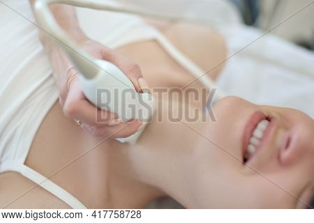 Doctor Conducts Ultrasound Examination Of Thyroid Gland Of Woman