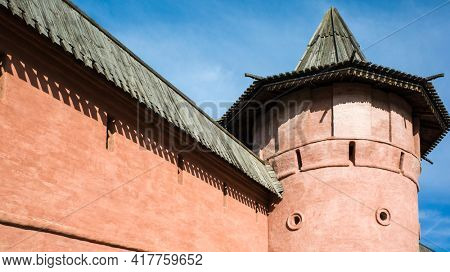 Detail of red wall and tower with wooden roof of Saint Euthymius monastery in Suzdal, Russian ancient architecture. Golden Ring of Russia
