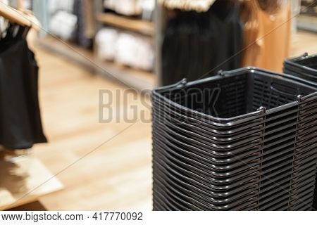 Shopping Carts Or Basckets Of Black Are Placed On Top Of Each Other At The Entrance To The Clothing 