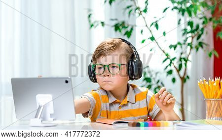 Back To School. Little Blond Boy Using Tablet Laptop Computer For Online Lesson. Child Writing Homew