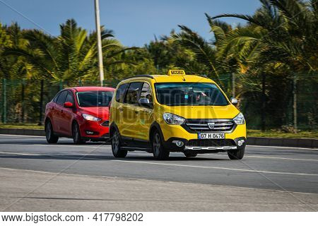 Alanya,  Turkey - April 12 2021:  White Taxi Car Dacia Lodgy Is Driving Fast On The Street On A Warm