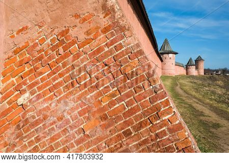 Detail of red bricks wall and towers of Saint Euthymius monastery in Suzdal, Russian heritage architecture. Golden Ring of Russia