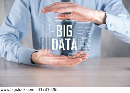 Businessman In A Suit On A Dark Background Holds The Inscription Big Data. Storage Network Online Se