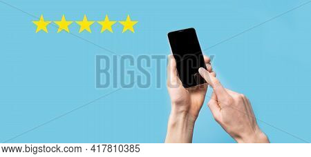 Man Holds Smart Phone In Hands And Gives Positive Rating, Icon Five Star Symbol To Increase Rating O