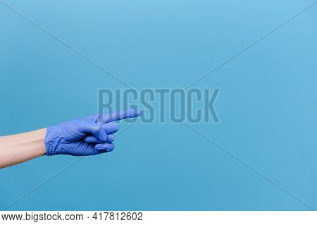 Close Up Of Male Finger Pointing At Copy Space, Wears Medical Protective Gloves, Isolated On Pastel 