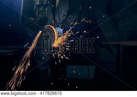 Close Up Of Fitter In Special Suit Cutting With Rotating Disc For Metal With Large Sparks. Concept O