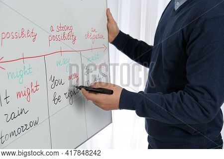 English Teacher Giving Lesson On Modal Verbs Near Whiteboard, Closeup