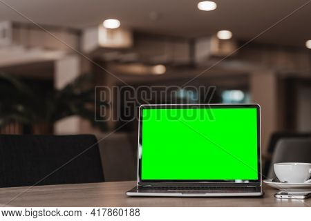 Mockup Of Laptop Computer With Empty Screen With Coffee Cup And Smartphone On Table Of The Coffee Sh