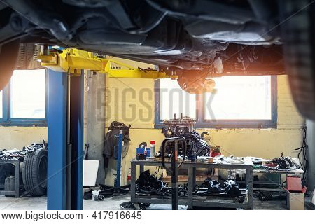 Bottom Pov Big Modern Suv Car With Removed Gearbox Raised On Lift Elevator At Workshop Service Maint