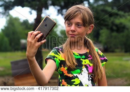 Selfie. A Ten Year Old Girl Poses And Takes A Selfie By Hand. Beautiful Teenage Girl Takes Selfie Wh