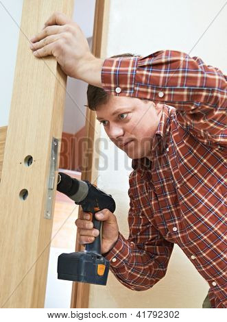 Mandlige handyman Tømrer på interiør træ dør lås installation