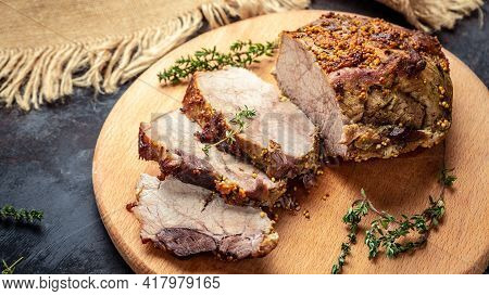 Large Sliced Piece Of Baked Pork Back Wwith Mustard And Thyme On A Wooden Board. Food Recipe Backgro
