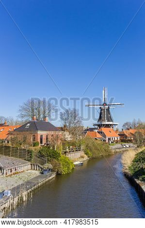 Historic Windmill At The River In Mesingeweer, Netherlands