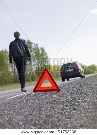 Warning triangle in front of a car breakdown