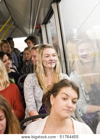 Happy woman on the bus with large group of people