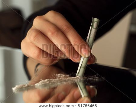 Human hand and drugs on a mirror