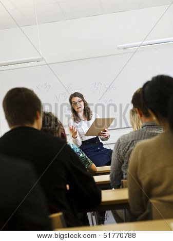 Schoolteacher in front of pupils in the classroom
