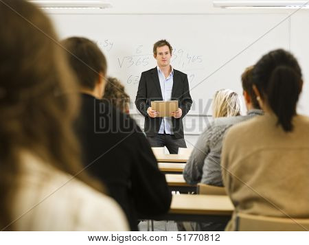Schoolteacher in front of pupils in the classroom