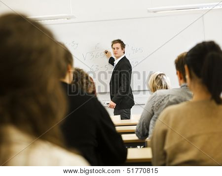 Schoolteacher in front of pupils in the classroom