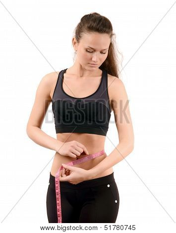Beautiful fit girl measuring her waist the a centimeter.