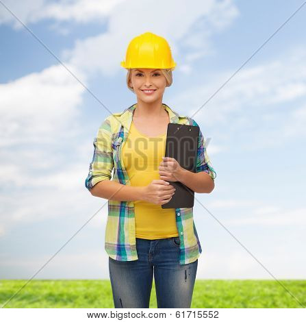 repair, construction and maintenance concept - smiling woman in helmet with clipboard